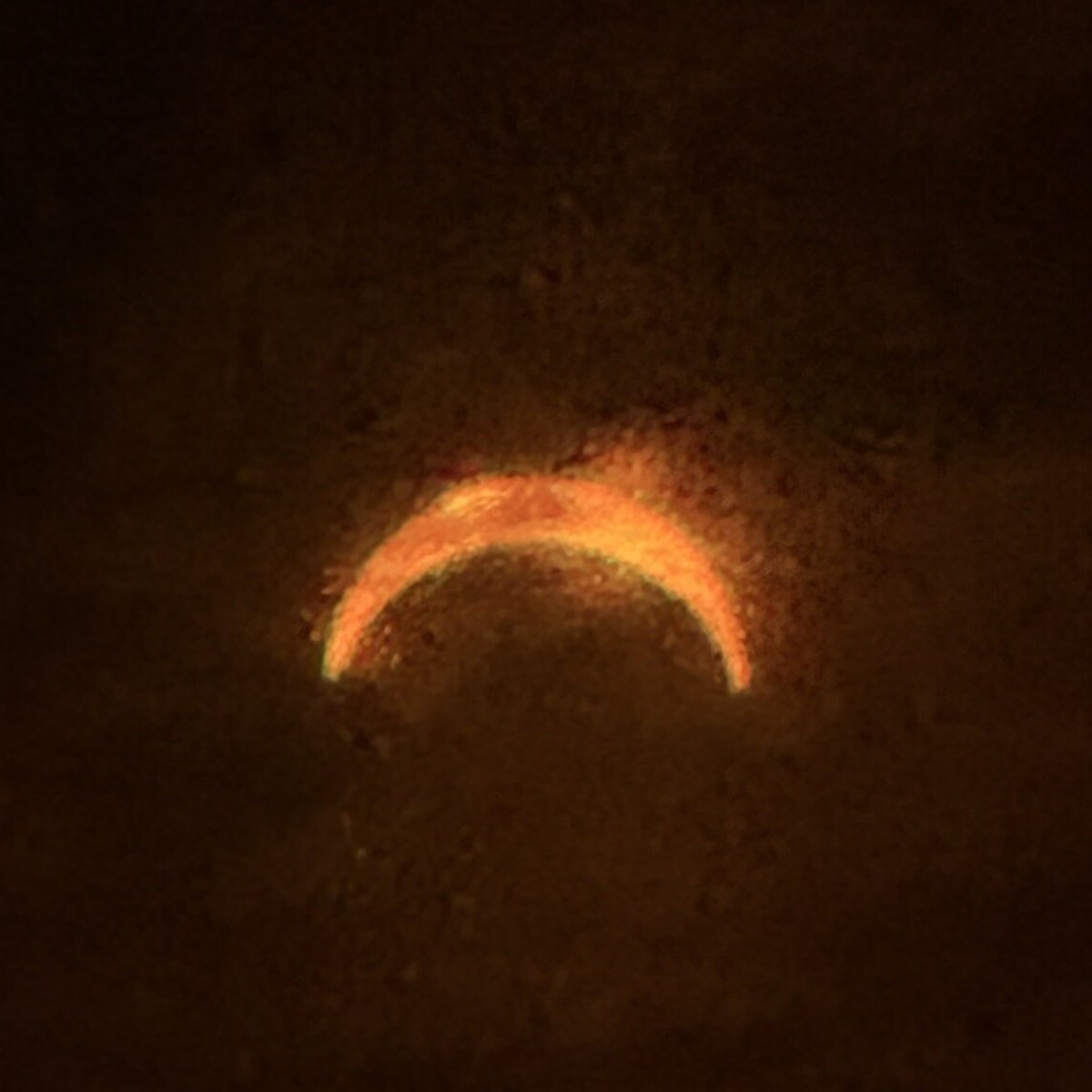 Eine schmale Sonnensichel kurz vor dem Maximum, durch d&uuml;nne Wolken fotografiert